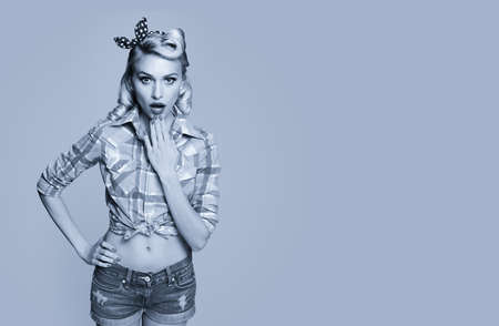 Portrait of beautiful surprised woman, dressed in pin up style. Blond girl posing in retro fashion and vintage concept. Black and white. Copy space.の写真素材