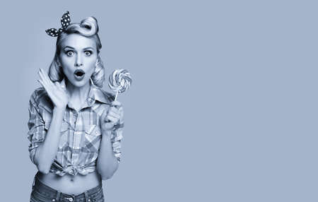 Woman with lollipop in pinup style. Blond girl posing in retro fashion and vintage concept. Black and white. Copy space.の写真素材