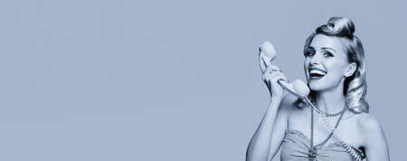 Portrait of beautiful happy smiling woman with phone, pin up style. Caucasian blond girl in retro fashion and vintage concept. Black and white. Copy space.の写真素材