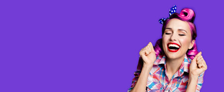 Unbelievable news! Excited surprised, very happy purple woman. Pin up girl with open mouth and closed eyes with raised hands. Retro and vintage concept. Violet background. Wide image with copy space area.の写真素材