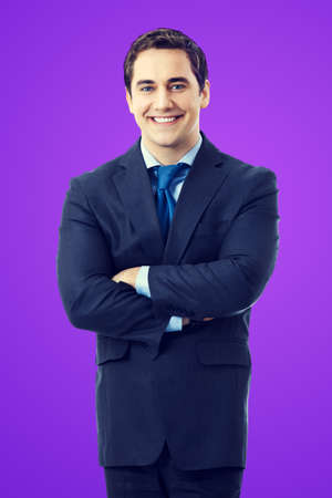 Portrait of smiling middle aged confident businessman, isolated over violet purple background. Happy business man in crossed arms pose at studio.の写真素材