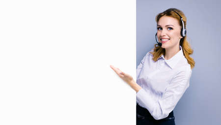 Call Center Service. Customer support or sales agent. Caller or receptionist phone operator showing banner with copy space. Helping, answering, consulting. Grey color background.の写真素材