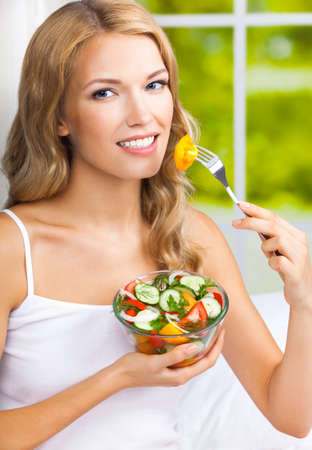 Portrait image of happy smiling woman with salad, indoor. Healthy eating, vegetarian, keto ketogenic diet concept.の写真素材