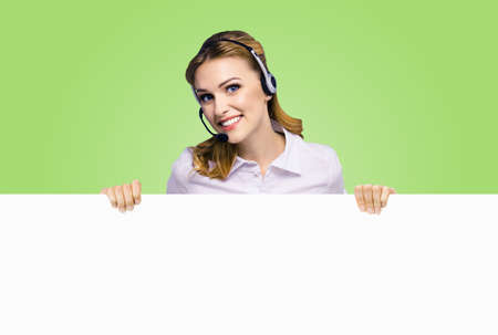 Call Center Service. Customer support or sales agent. Business woman or caller phone operator showing sign board or billboard with copy space. Helping, answering, consulting. Green colour background.の写真素材