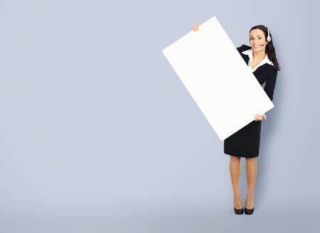 Call Center Service. Customer support or sales agent. Businesswoman or caller or phone operator hold banner with copy space. Full body of business woman with white empty signboard. Help answering ad.の写真素材