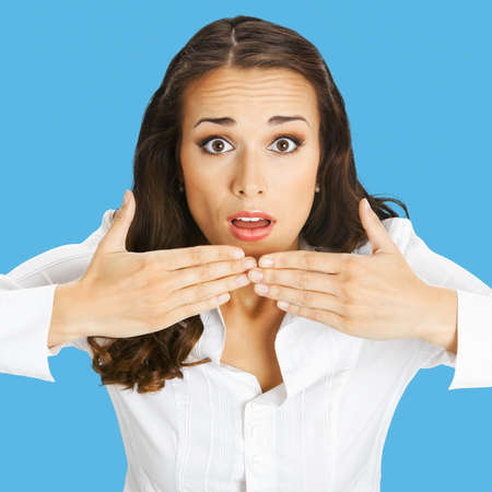 Unbelievable news! Excited surprised, shocked businesswoman. Business woman covering open mouth by hands. Isolated over blue color background. Square composition.の写真素材