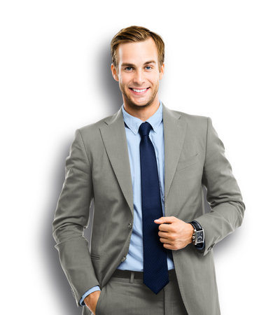 Portrait of happy confident businessman in grey suit, blue shirt and tie, isolated on white background. Business success concept. Smiling man at studio picture.の写真素材