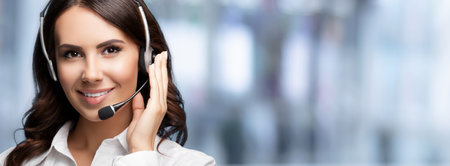 Call Center Service. Customer support or sales agent, over blured office background. Female caller or receptionist phone operator. Copy space for text area. Help, answering and telemarketing.の写真素材