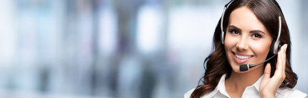 Call Center Service. Beautiful customer support or sales agent. Caller or receptionist phone operator. Helping, answering, consulting. Blurred office background.の写真素材