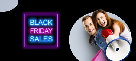 Happy excited couple with megaphone and shopping bags. Man and woman shout saying in loudspeaker mega phone. Big deals, discounts offers concept. Black Friday sales neon light sign. Grey back.の写真素材