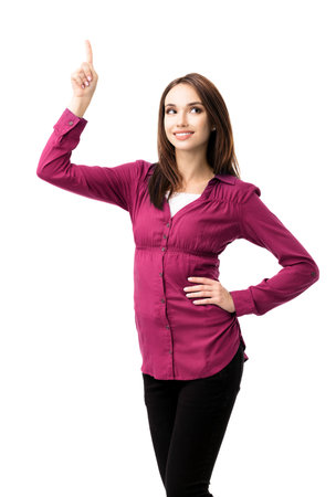 Portrait image of happy smiling looking up young woman in casual smart red clothing, showing something or copyspace for text or slogan, isolated over white background. Have idea concept.の写真素材