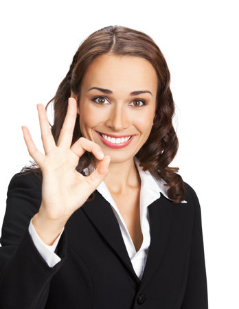 Portrait image of happy smiling young business woman in black confident suit showing ok okay gesture, isolated on white background. Female executive office worker, teacher or real estate agent.の写真素材