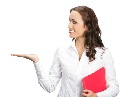 Portrait image of happy smiling business woman with red folder showing, pointing, advertising, isolated white background. Profile side businesswoman, office worker, teacher or real estate agent.の写真素材