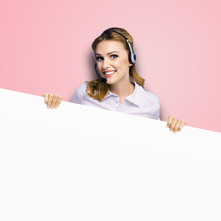 Call Center Service. Customer support or sales agent. Business woman or caller or receptionist phone operator showing emty sign board or billboard with copy space. Rose pink background. Helping.の写真素材