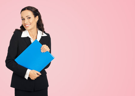 Portrait of happy smiling business woman with blue folder, isolated over  rose pink backgroundの写真素材
