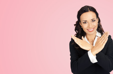 Happy smiling young business woman showing stop gesture, isolated over rose pink color background.の写真素材