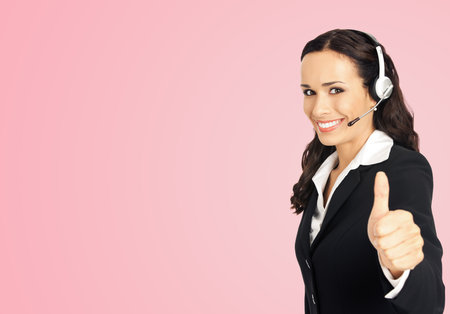 Call center service. Customer support phone sales operator in headset showing thumb up gesture, over rose pink background with copy space area for text or slogan.の写真素材