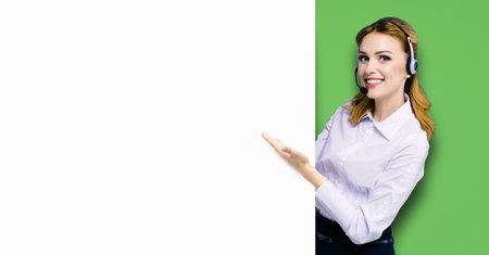 Call Center Service. Customer support or sales agent. Businesswoman or caller or receptionist phone operator showing banner with copy space. Helping, answering, consulting. Bright green background.の写真素材