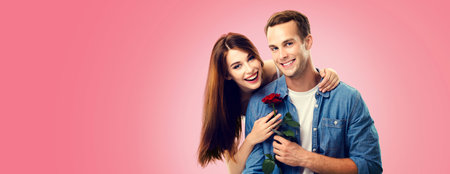 Love, relationship, dating, flirting, romantic concept - portrait picture of happy couple with flower, isolated on vivid rose pink background. Copy space for some text.の写真素材