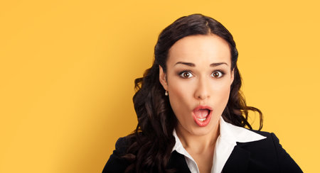 Wow. Face portrait excited surprise, shock happy business woman businesswoman with wide open mouth and eyes isolate against yellow background. Unbelievable sale offer, rebate deal action ad conceptの写真素材