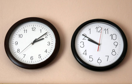 Two Clock on the wall one in reverseの写真素材
