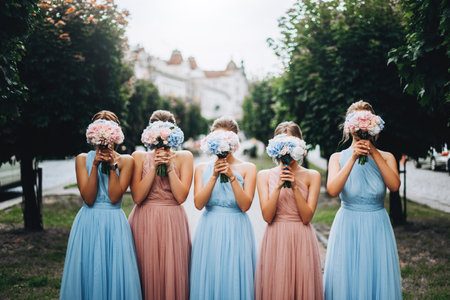 Bridesmaids at wedding with bouquets in hands. Girl in colored dresses for wedding.の写真素材