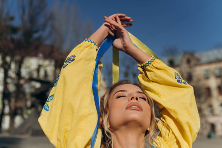 the hands of a young girl hold the Ukrainian flag. A girl in an embroidered shirt. free Ukraineの写真素材