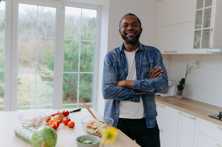 portrait of an African-American man standing in the kitchen preparing lunch, breakfast.の写真素材