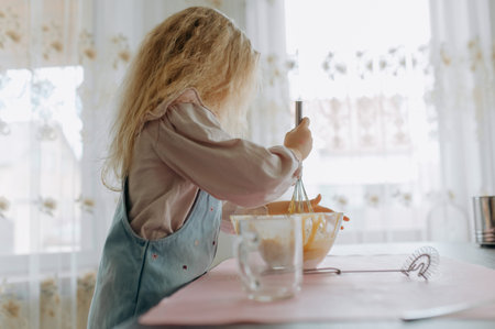little girl kneads dough for cookies, cake, bread, pancakes.