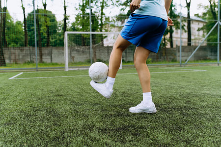 girl soccer player works with the ball on the soccer field. football player in trainingの写真素材