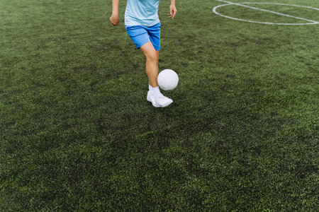 girl soccer player works with the ball on the soccer field. football player in trainingの写真素材