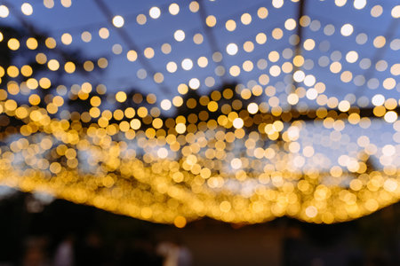 Garlands of lamps on a wooden stand on the street. A wedding banquet. evening lights evening decor. out of focusの写真素材