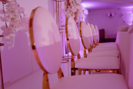 a row of golden metal chairs at a wedding banquet. the back of the chair is goldの写真素材