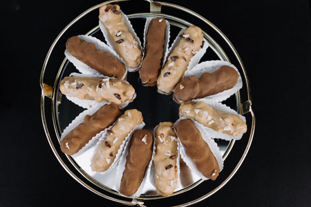 Eclairs sprinkled with cream. Close up. Candy bar. brown sweet eclairs. top view