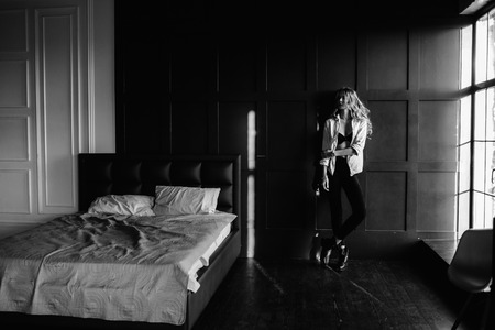 Young beautiful woman model in a white shirt, black jeans, confident, blue backgroundの写真素材