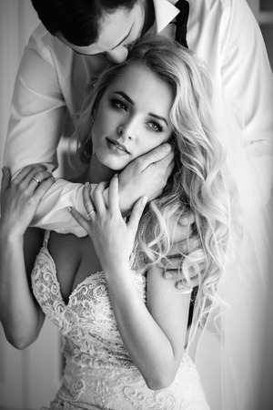 Bride and groom at the wedding Day. Wedding couple, happy newlywed woman and man, in a beautiful hotel room, studio. Loving couple. Bride and groomの写真素材