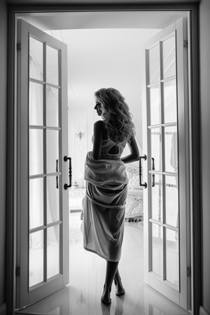beautiful young blonde in a negligee in full growth in an expensive houseの写真素材