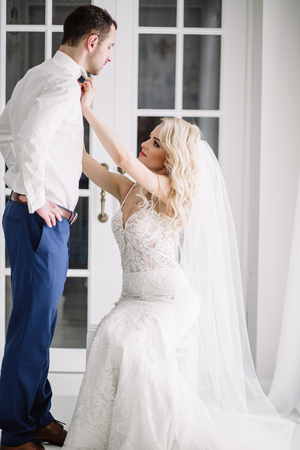 Bride and groom at the wedding Day. Wedding couple, happy newlywed woman and man, in a beautiful hotel room, studio. Loving couple. Bride and groomの写真素材
