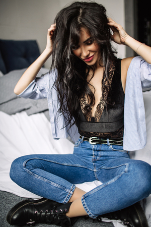 cute young woman sitting on the floor in blue jeans and blue shirt, fashionの写真素材