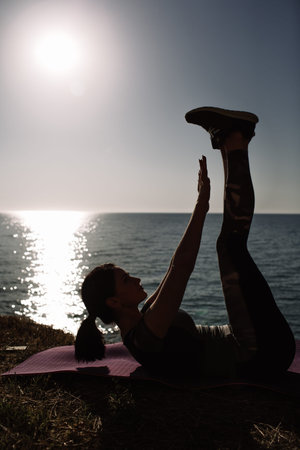 beautiful girl with sports forms sports on the beach, drinking water, jumping, running, doing different exercisesの写真素材