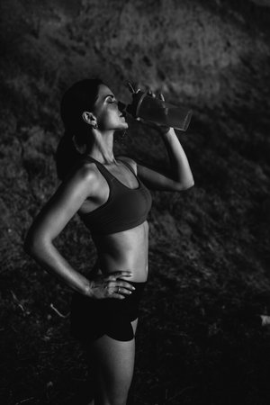 beautiful girl with sports forms sports on the beach, drinking water, jumping, running, doing different exercisesの写真素材