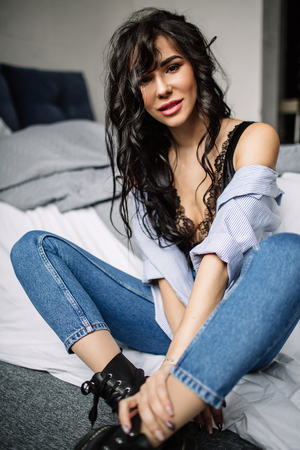 cute young woman sitting on the floor in blue jeans and blue shirt, fashionの写真素材