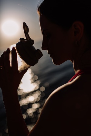 beautiful girl with sports forms sports on the beach, drinking water, jumping, running, doing different exercisesの写真素材