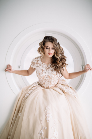 the bride sits in the round window, smiling. look at the camera in Natural lightの写真素材