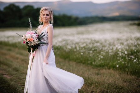 Beautiful woman enjoying daisy field, nice female lying down in meadow of flowers, pretty girl relaxing outdoor, having fun, happy young lady and spring green nature, harmony concept.の写真素材