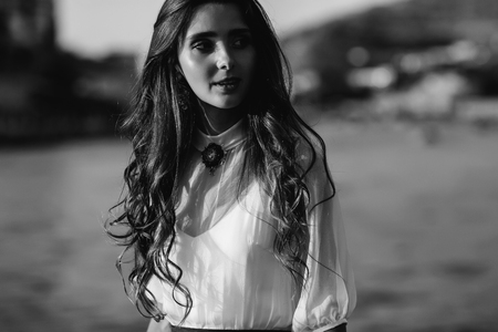 Beautiful girl walking on the pier by the sea near the yacht, boats in the blue long dressの写真素材