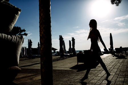 Beautiful girl brunette in the blue sunglasses in swimsuit, sexy model, perfect figure, sunlightの写真素材