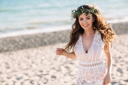 Beautiful girl on the beach in a beautiful dress. Sunny day, white sand, boho.の写真素材