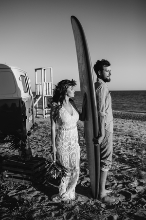 Happy surfers couple standing with surfboards on the sandy beachの写真素材