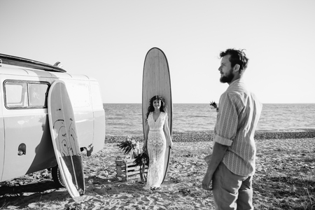 Happy surfers couple standing with surfboards on the sandy beachの写真素材